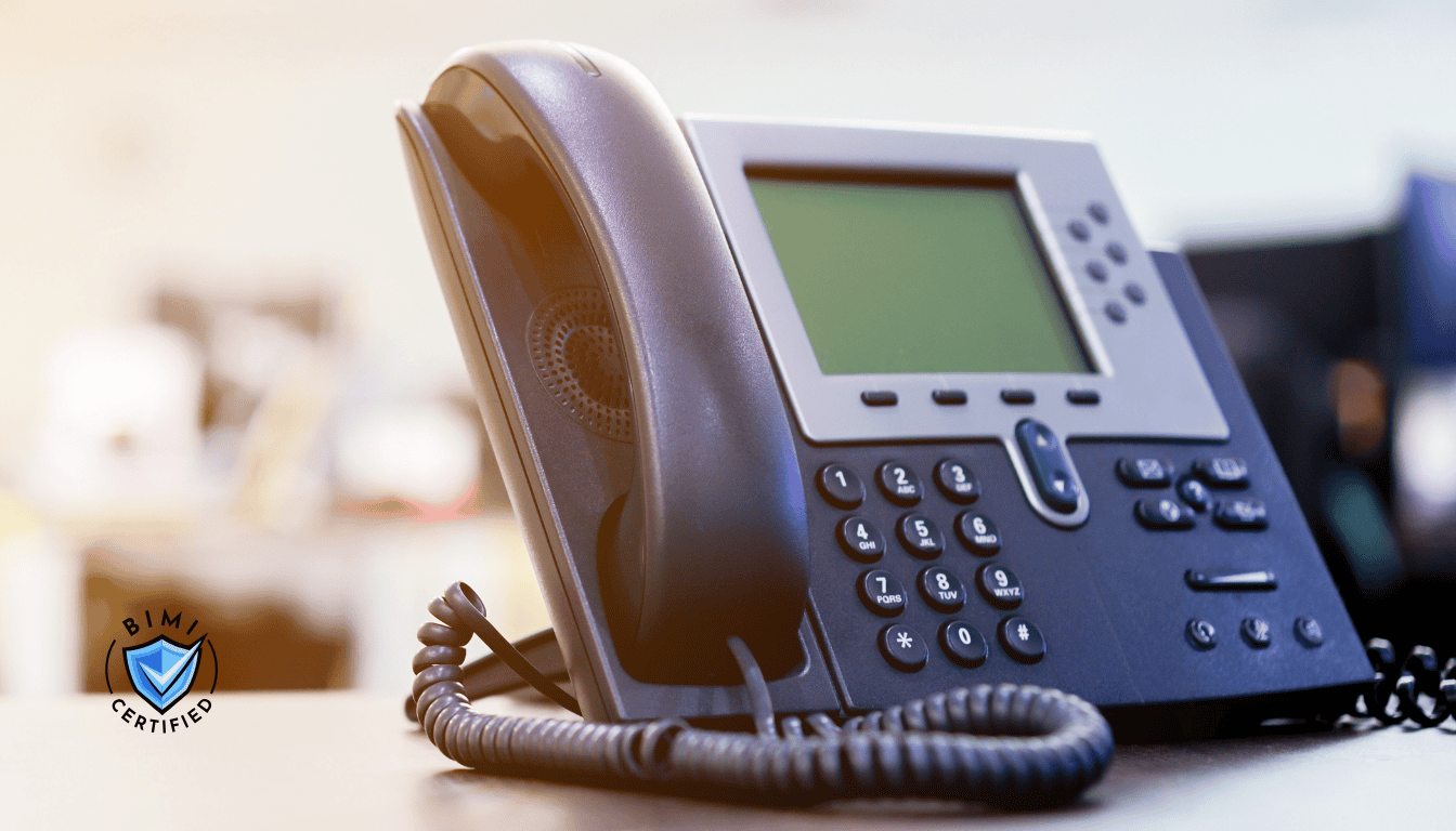 Mūsdienīgs telefons uz galda gaida BIMI verifikācijas zvanu